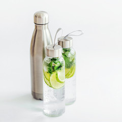 Fresh lime and mint infused water, cocktail, detox drink, lemonade in reusable bottles. Summer drinks. Health care concept.