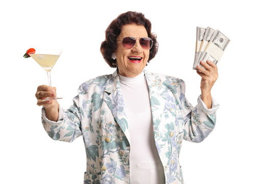 Happy senior woman holding cocktail and money