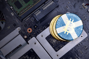 golden bitcoins with flag of scotland on a computer electronic circuit board. bitcoin mining...