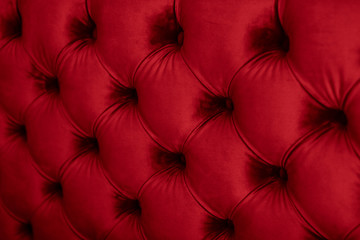 Red luxury velour quilted sofa upholstery with buttons, elegant home decor texture and background