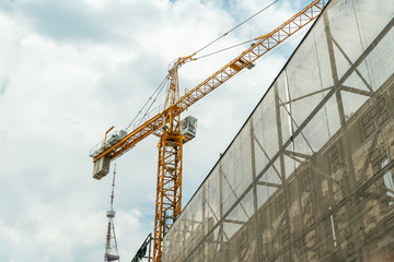 Reconstruction of the old building. Yellow Crane. Restoration of the building against the sky with clouds, view from the bottom up. Georgia, Tbilisi