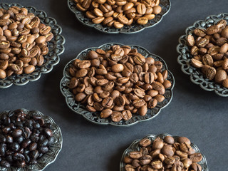 Varieties of roasted coffee beans on a black table