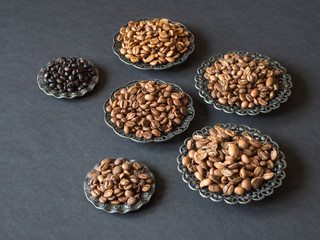 Varieties of roasted coffee beans on a black table