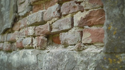 Plastered wall with exposed decaying of erosion brickwork of 18th century building. Old brickwork of the 18th century