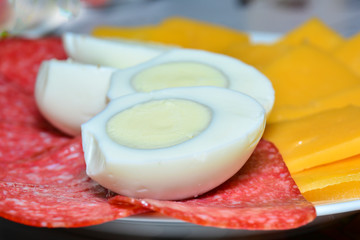 Cutting cheese and sausage, boiled eggs cut in half. Concept of gastronomic background, ingredients for a sandwich, background for the project and design.