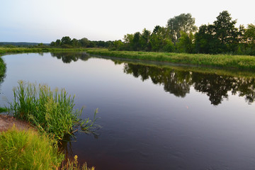 River landscape on a summer evening in Belarus, river Schara at Slonim village. Summer nature river landscape. Picturesque nature, rural river landscape