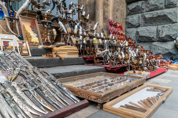 Caucasian traditional daggers and horns, decorated in traditional embossed, chased, filigree patterns and stone inlay for sale on the tourist markets