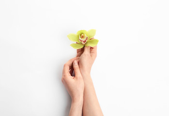 Young woman holding beautiful orchid flower on white background