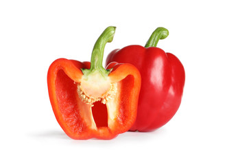 Cut and whole ripe red bell peppers on white background