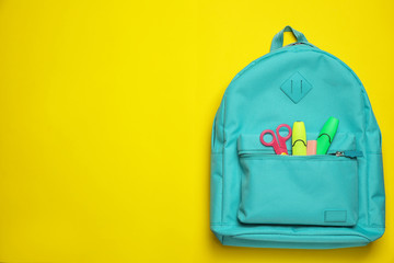Fototapeta Stylish backpack with different school stationary on yellow background, top view. Space for text obraz