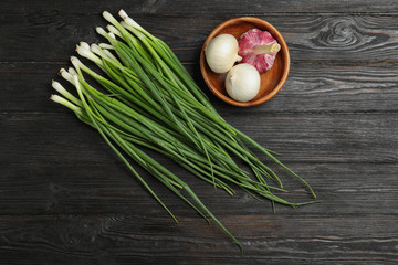 Fototapeta na wymiar Flat lay composition of onions and garlic on dark wooden table