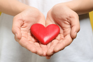 Woman holding red heart, closeup. Donation concept