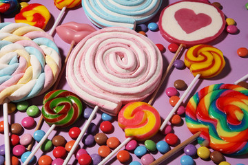 Fototapeta na wymiar lollipop candies with jelly and sugar. colorful array of different childs sweets and treats on color background