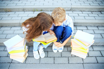 Little boy and girl are studying a book. The concept is back to school, education, reading,...