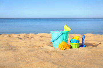Set of plastic beach toys on sand near sea. Space for text