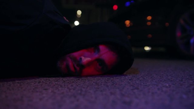 Ganster lying on ground police caught a bandit silen light in the dark at night police protection arrest balaclava crowbar dangerous defense handcuffs masked people person violence