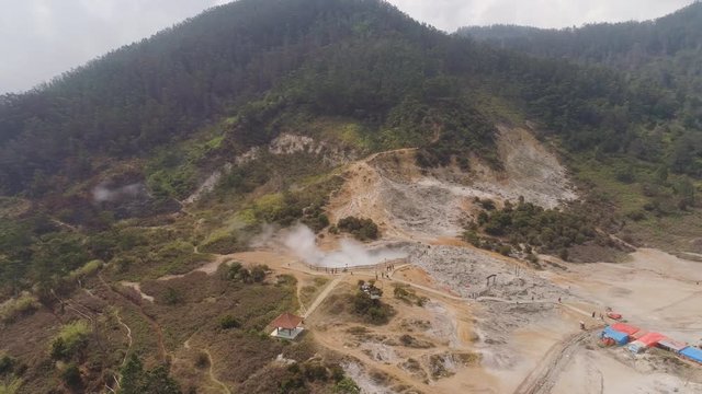 plateau with volcanic activity, mud volcano Kawah Sikidang, geothermal activity and geysers. aerial view volcanic landscape Dieng Plateau, Indonesia. Famous tourist destination of Sikidang Crater it