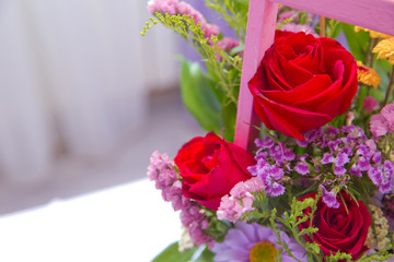 Pink bouquet of multicolored roses . Red , purple flower picture close up in the bouquet. Ribbon . Pink bouquet of fresh purple, red, Pink, white , blue, orange roses .