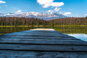 Dock on a lake with mountains in the background