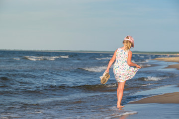 dziewczynka w letniej sukience na morskiej plaży,  - obrazy, fototapety, plakaty