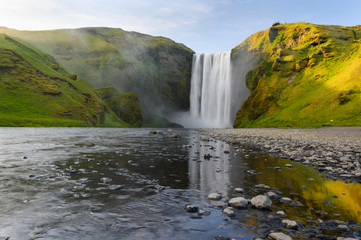 Fototapeta na wymiar Scenery summer long exposure view of famous Skogafoss waterfall with reflection in stream surface
