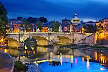 ROME, ITALY. Ponte Vittorio Emanuele II and Tiber river, as seen from Ponte Sant'Angelo. In the background the dome of St Peter's Basilica.