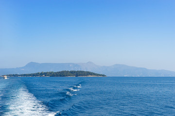 Fototapeta na wymiar Vido Island near the Corfu town from the ship in summer day