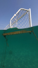 Underwater sea level photo of Polo goal post complete with net with nobody around as seen in turquoise Mediterranean bay
