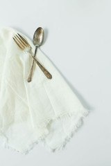 Rustic Fork and Spoon on Linen Napkin and White Background, Vintage Silverware, Antique Flatware, Copy Space