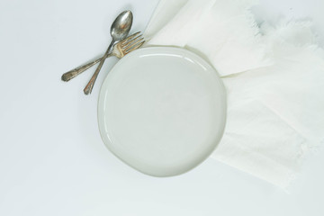 White Ceramic Plate with Spoon and Fork and Linen Napkin, Empty Dish, Table Setting, White Background