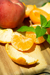 Still Life Close Up of Summer Fruit on Wooden Serving Board in Direct Sunlight, Peach, Orange, and Nectarine