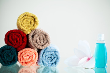 Fototapeta na wymiar Colored towels on white table with copy space on bath room background