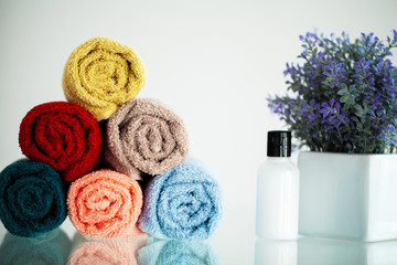Obraz na płótnie Canvas Colored towels on white table with copy space on bath room background