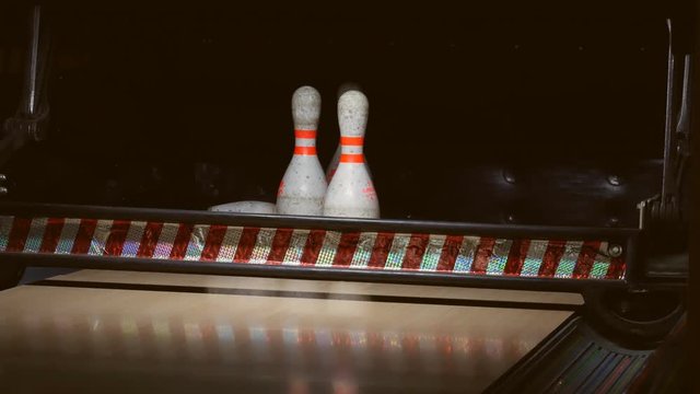 Bowling ball falls into a bowling alley. Frayed Pins