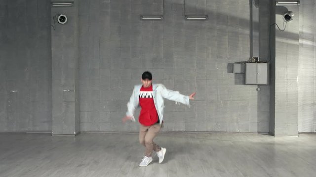Young stylish man is dancing. Young handsome guy dancing against grunge wall. Breakdance concept.