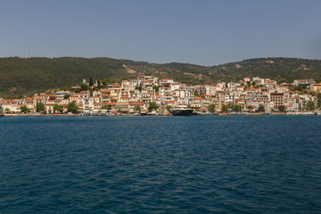 Fototapeta na wymiar Landscape view to Skiathos island from the sea. Old bildings of town. Greece