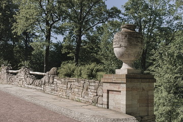 a huge stone vase adorns the railing of the ruin bridge in Alexandria park in Petergof