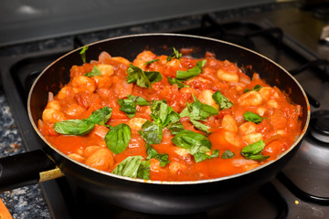 Home made Italian pasta dish with rich sauce cooking in a pan