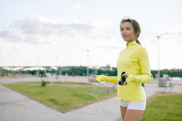 Cardio workout outdoors before running. Young european sensitive woman skipping rope. Exercising...