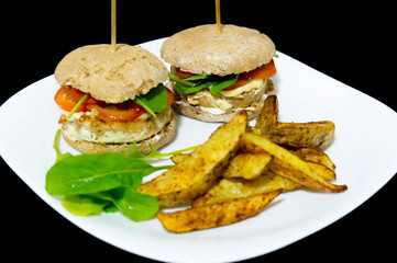  Salmon burger with rustic potatoes and rucula leaves.