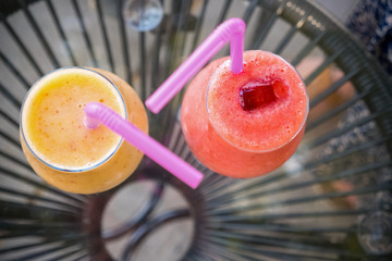 Refreshing drink with ice. Summer drinks. Freshly blended fruit smoothies of various colors and tastes in glass jars. Grapefruit, strawberry cocktail. Vegan drinks on glass table. Detox concept