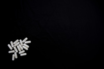 white pills on black background. medical pharmacy