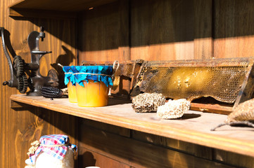 Shelves with jars of seeds and jars of honey next to honeycombs.