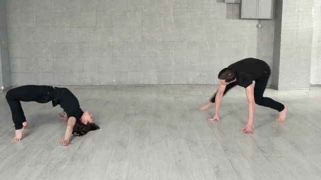 Modern style dancers exercising in studio. Man and woman performing dance moves. Sport, dancing and urban culture concept.