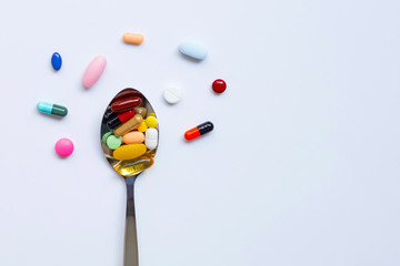 Colorful tablets with capsules and pills on white.