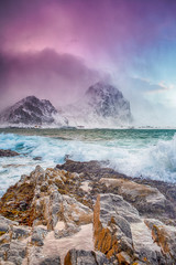 Arctic Ocean Near Rocky Shore of Picturesque Lofoten Islands Against Snowy Mountains in Norway at Spring.
