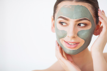 Skin Care. Young Woman With Cosmetic Clay Mask Holding Cucumber At Her Bathroom