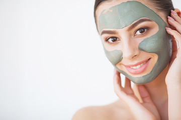 Skin Care. Young Woman With Cosmetic Clay Mask Holding Cucumber At Her Bathroom