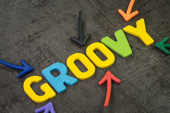Groovy modern programming language for software development or application concept, multi color arrows pointing to the word Groovy at the center of black cement chalkboard wall