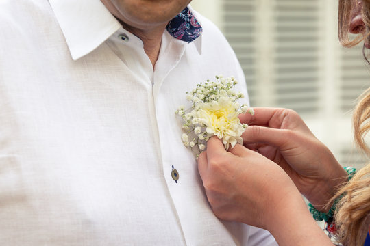 Groom´s boutonniere. Happy groom with a linen white guayabera on his wedding day. Happy and thoughtful man getting ready to get married. Casual style groom wear for wedding.